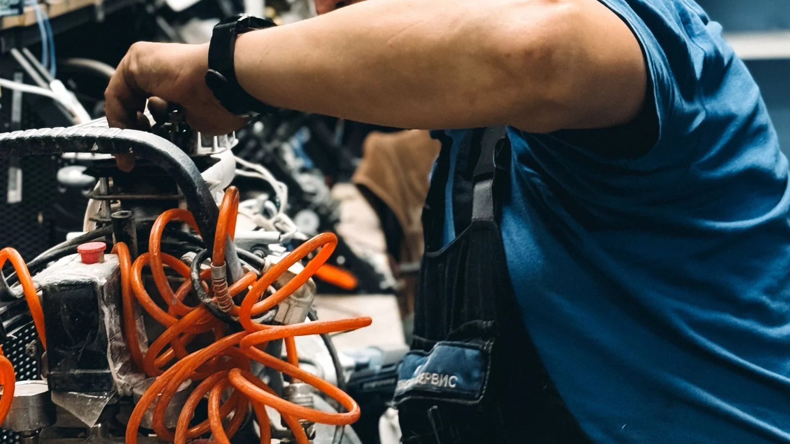 Mechanic repairing an air compressor in a workshop