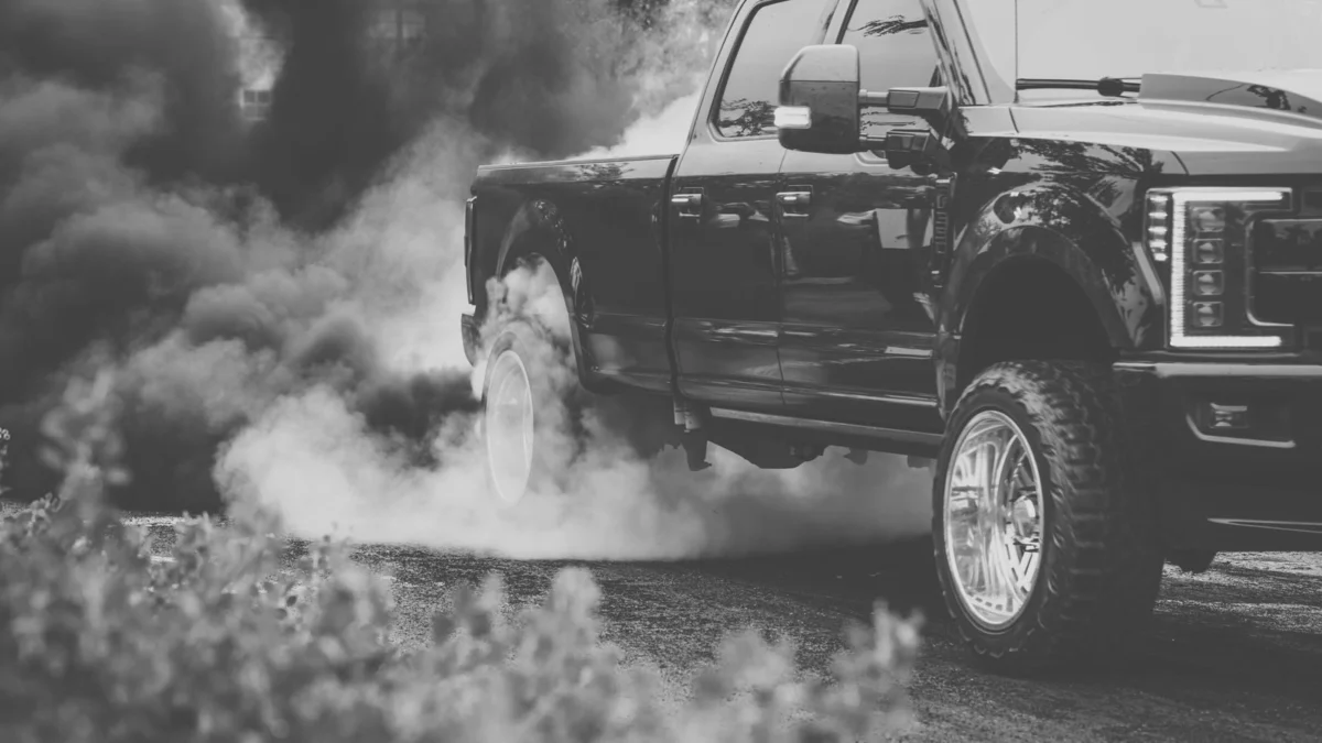 Black pickup truck emitting thick exhaust smoke
