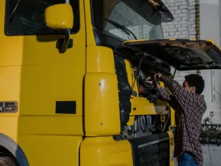 Mechanic working on a truck engine with the cab tilted