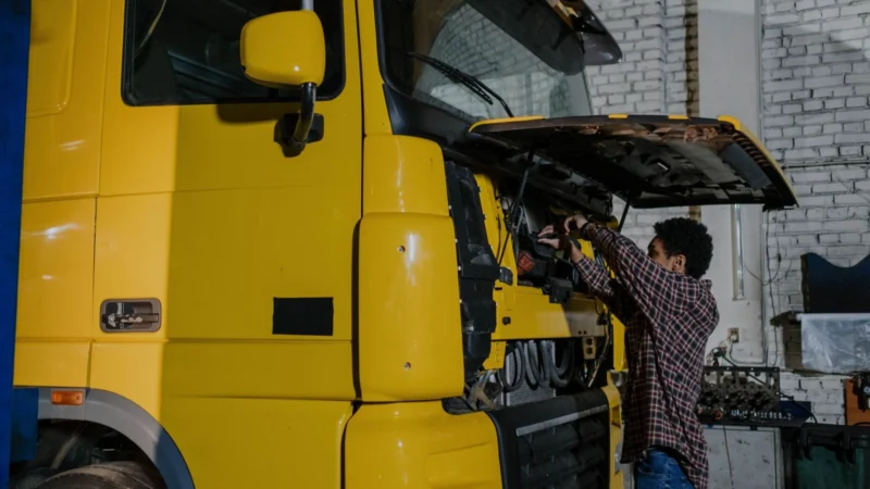 Mechanic working on a truck engine with the cab tilted