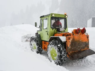 Tractor with snowplow clearing heavy snow