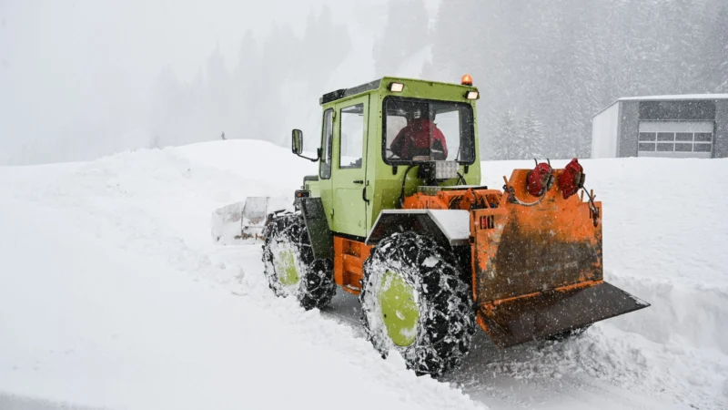Tractor with snowplow clearing heavy snow