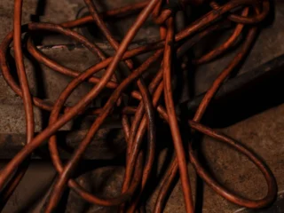 Coiled orange extension cords on a wooden floor
