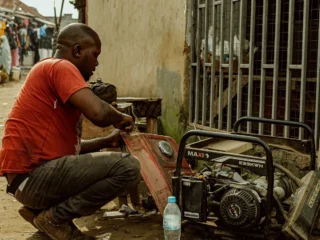 Man in a red shirt repairing a portable generator