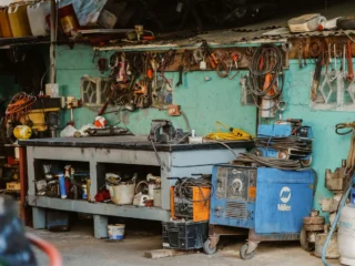 Cluttered home workshop with tools and welding equipment